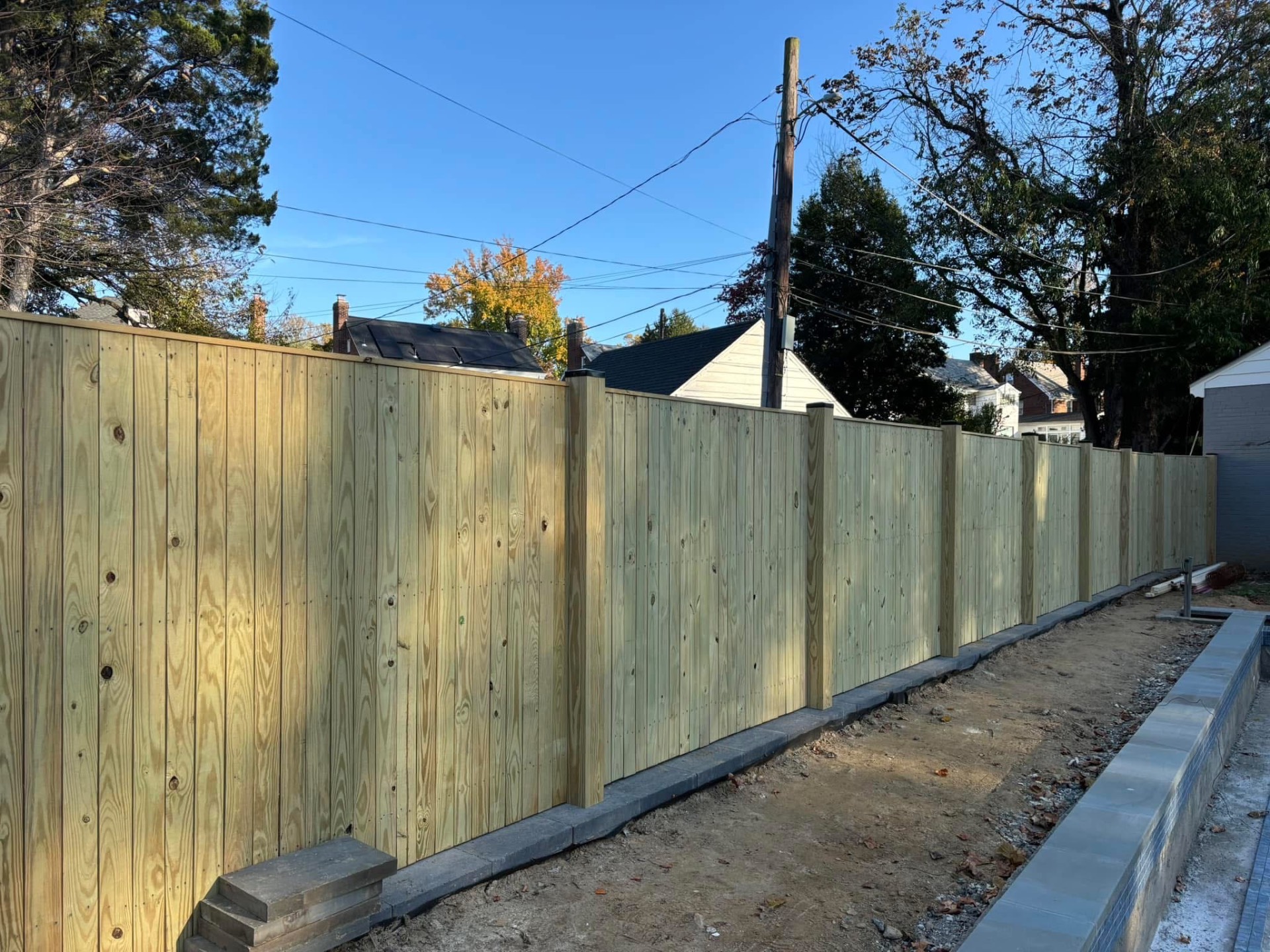 Pressure-treated privacy fence along paver patio