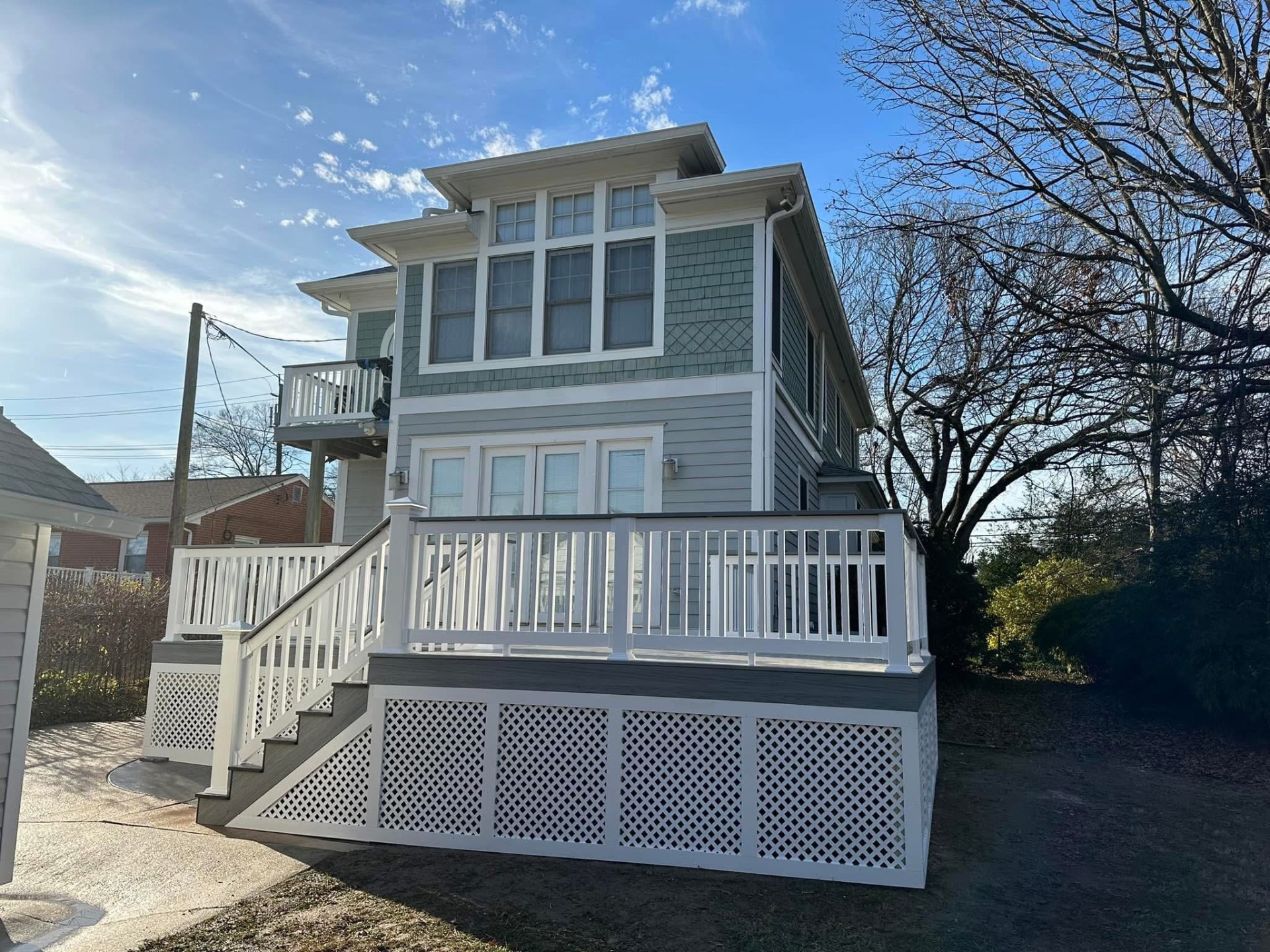 Coastal shingle home with wrap deck