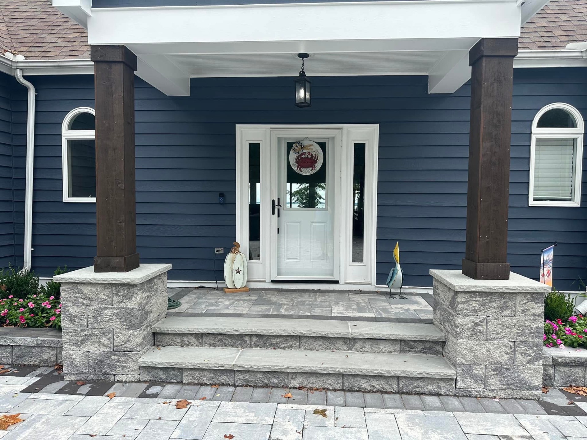 Navy siding with stone paver entry and wood columns