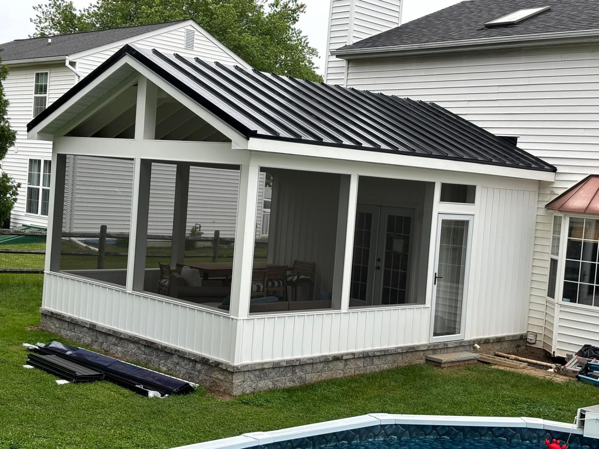 Screen room addition with black standing-seam metal roof