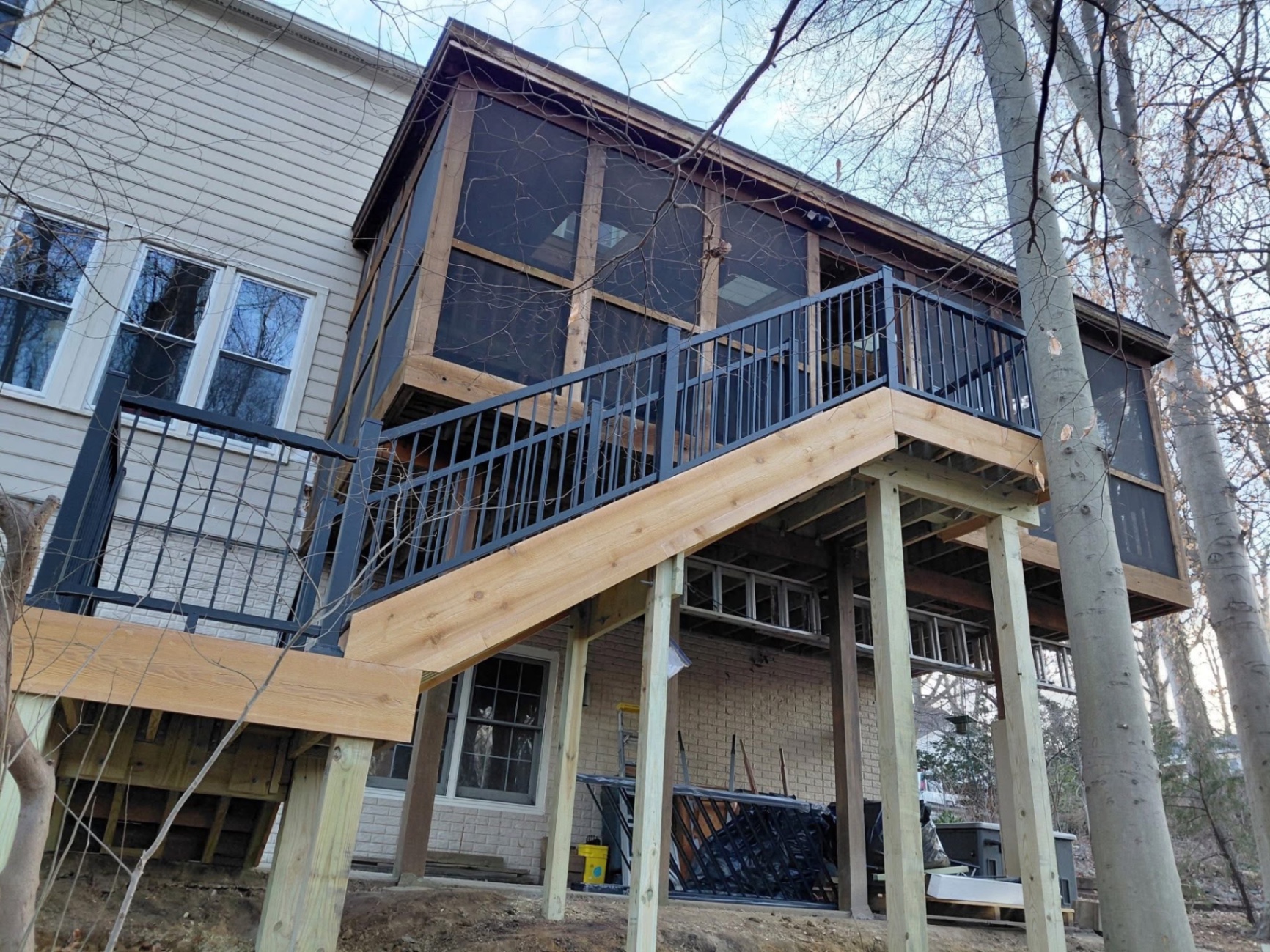 Wood deck with staircase and screened porch addition